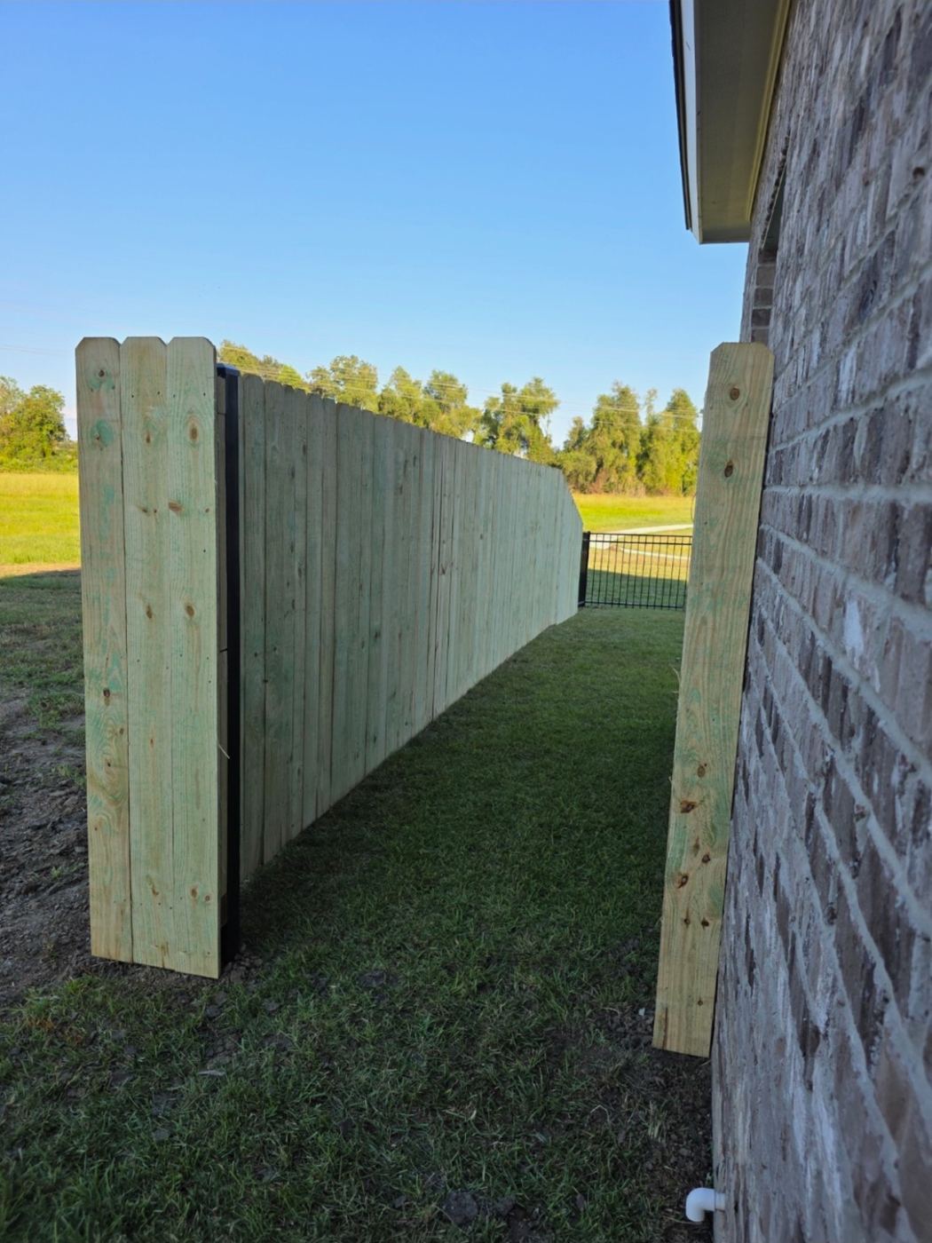 Wood fence tied into aluminum fence and brick house